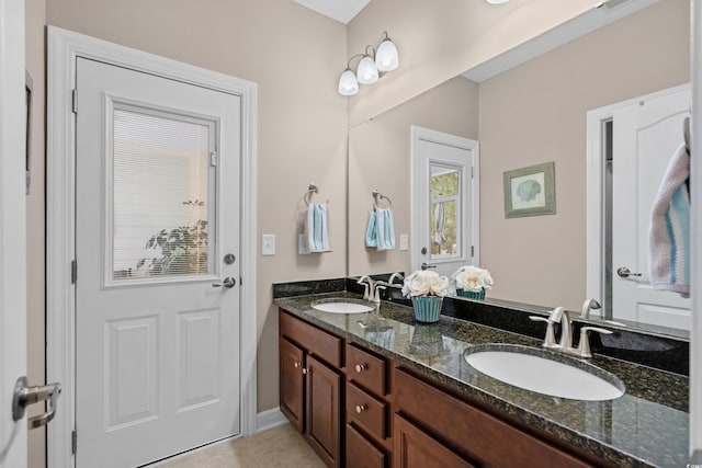 bathroom featuring double vanity, visible vents, a sink, and tile patterned flooring