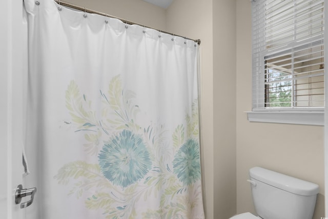 bathroom featuring curtained shower and toilet