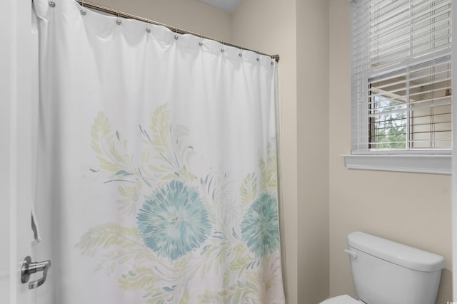 full bath featuring toilet and curtained shower