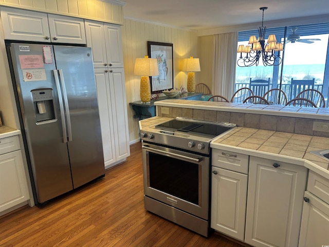 kitchen featuring tile countertops, stainless steel appliances, and white cabinetry