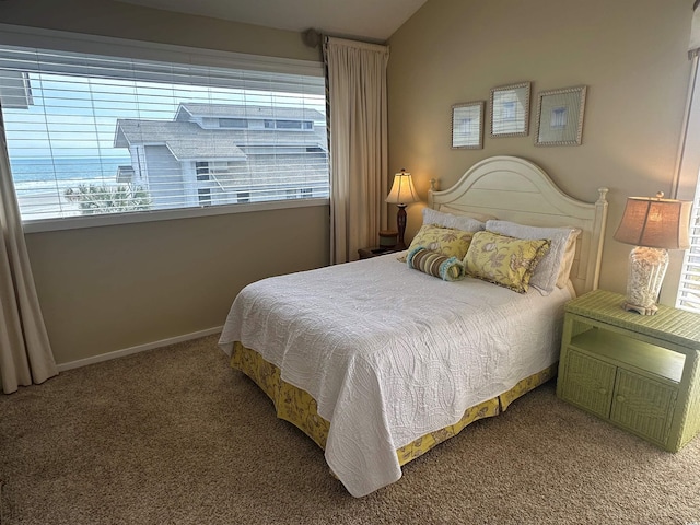 carpeted bedroom featuring lofted ceiling, multiple windows, and baseboards