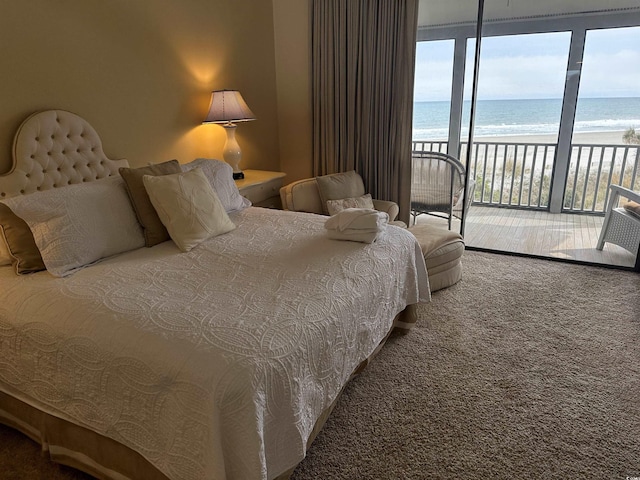 carpeted bedroom featuring a water view, a view of the beach, and access to exterior