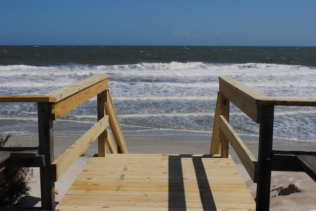 dock area featuring a water view and a beach view