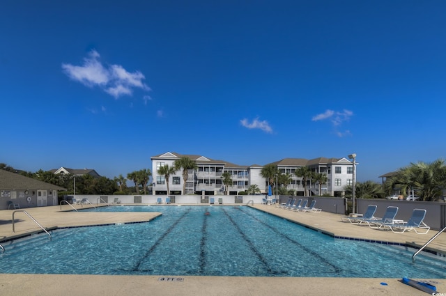 community pool featuring a patio area, a residential view, and fence