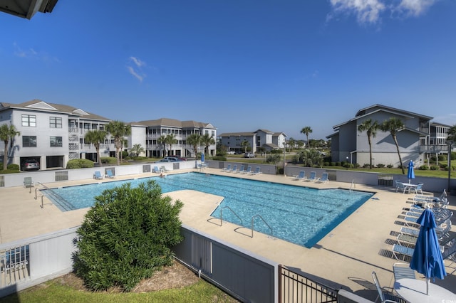 pool with a patio area and a residential view