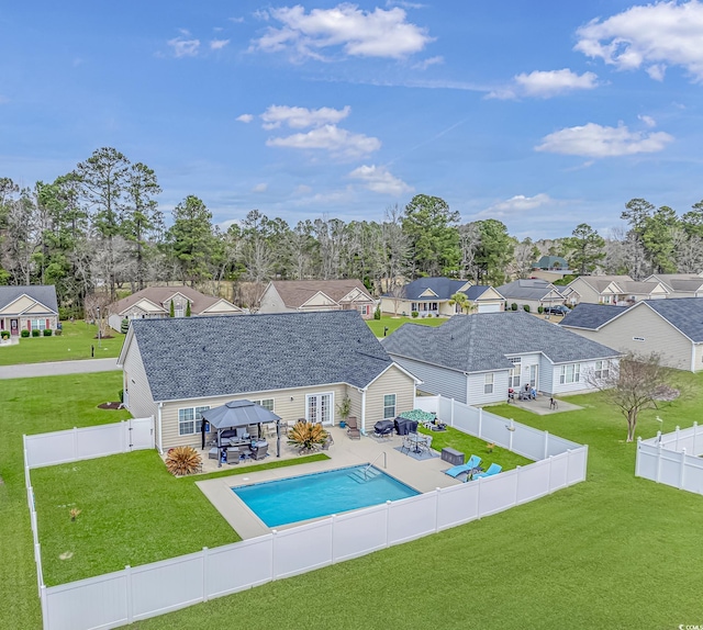 view of pool featuring a lawn, a patio, a fenced backyard, a gazebo, and a residential view