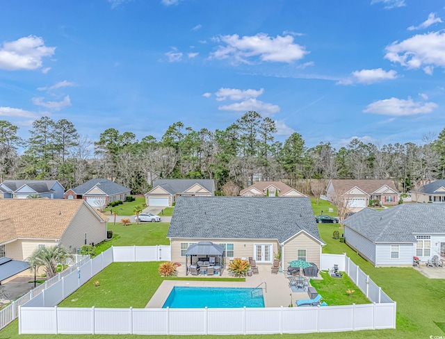 view of pool featuring a residential view, a gazebo, a lawn, a fenced backyard, and outdoor dining space