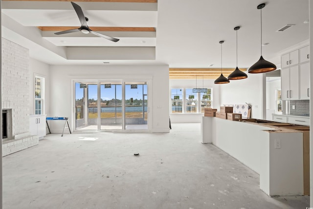 unfurnished living room featuring a brick fireplace, a ceiling fan, visible vents, and unfinished concrete flooring