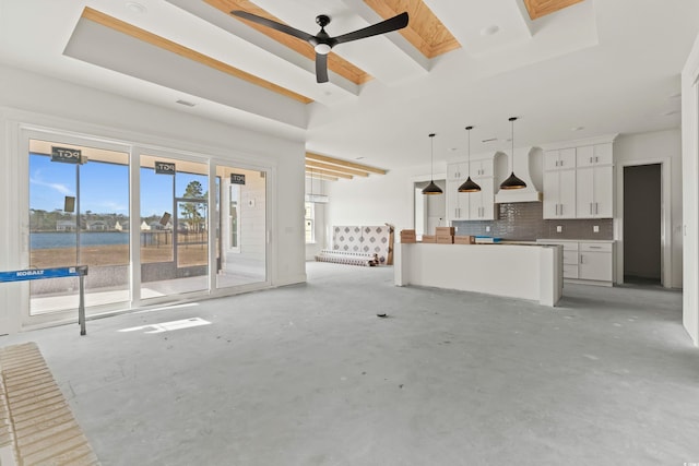 unfurnished living room featuring a skylight, ceiling fan, and unfinished concrete flooring