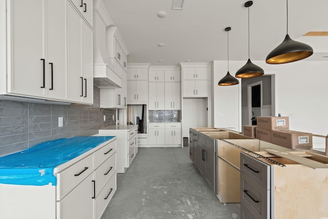 kitchen with concrete flooring, visible vents, white cabinets, decorative backsplash, and a center island