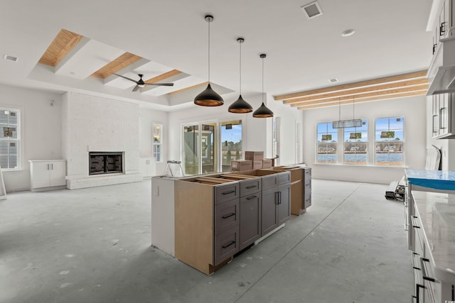 kitchen featuring concrete flooring, a brick fireplace, gray cabinets, and plenty of natural light