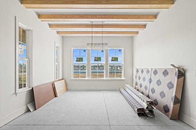 interior space with beam ceiling and baseboards