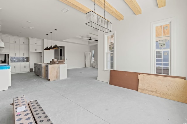 unfurnished living room featuring ceiling fan, beamed ceiling, and concrete floors