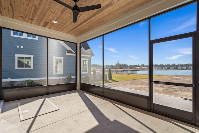 unfurnished sunroom with ceiling fan, a water view, and wooden ceiling