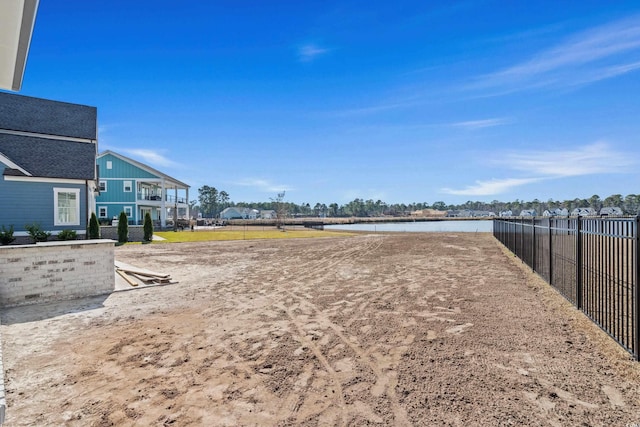 view of yard featuring a water view and fence