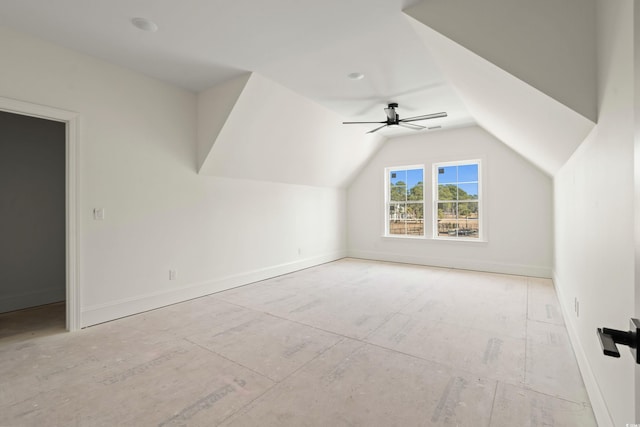 additional living space featuring lofted ceiling, a ceiling fan, and baseboards