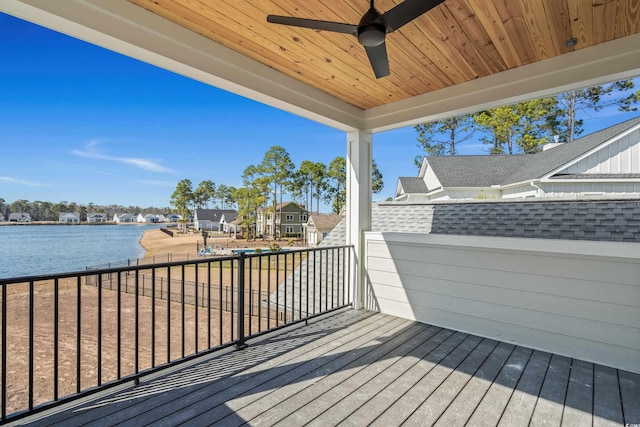 deck with a water view and ceiling fan