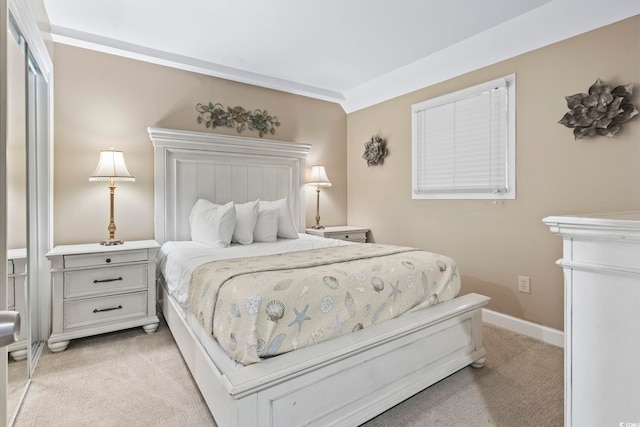 bedroom featuring light carpet and baseboards