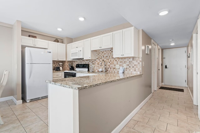 kitchen featuring white appliances, decorative backsplash, a sink, and light stone countertops