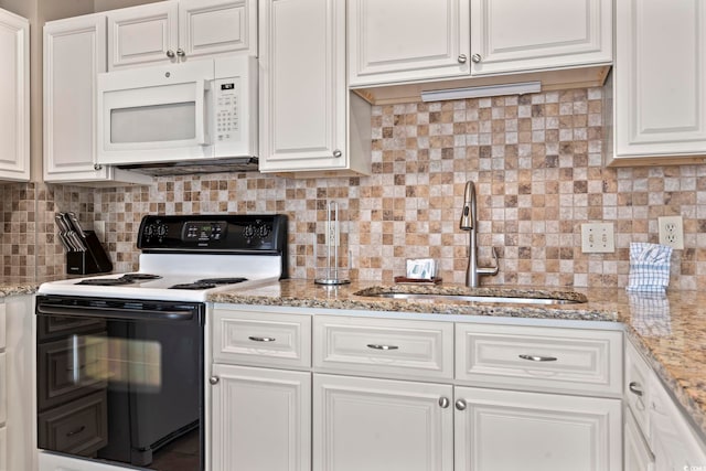 kitchen with range with electric stovetop, decorative backsplash, white microwave, white cabinets, and a sink