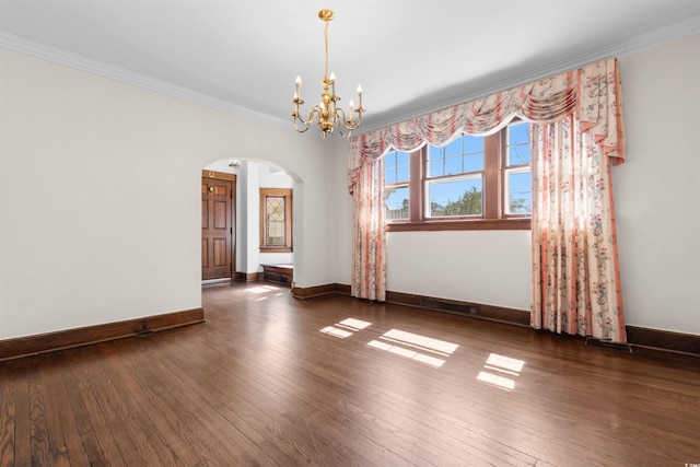 empty room featuring arched walkways, crown molding, a chandelier, baseboards, and hardwood / wood-style flooring