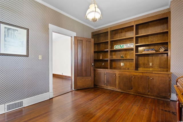 empty room with wallpapered walls, baseboards, ornamental molding, and dark wood-type flooring