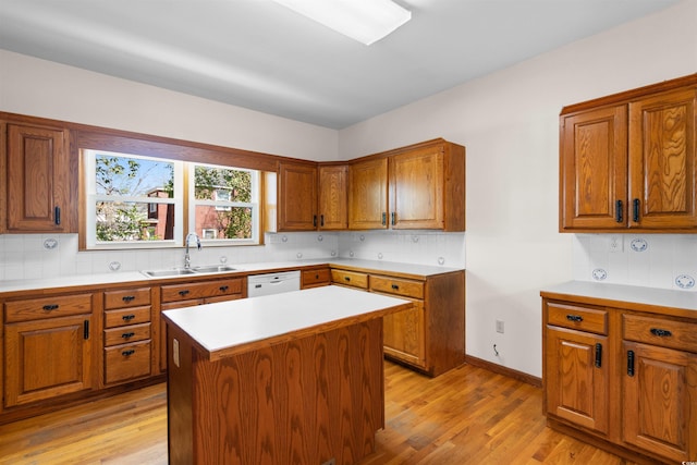 kitchen with light wood-style floors, brown cabinetry, and a sink