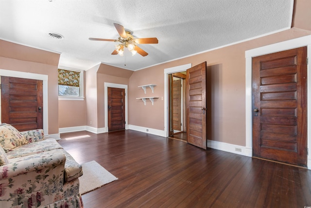 living area with visible vents, a textured ceiling, baseboards, and wood finished floors