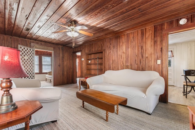 living room with visible vents, wood walls, wood ceiling, and a ceiling fan