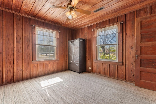 unfurnished bedroom featuring carpet floors, wood ceiling, visible vents, and wooden walls