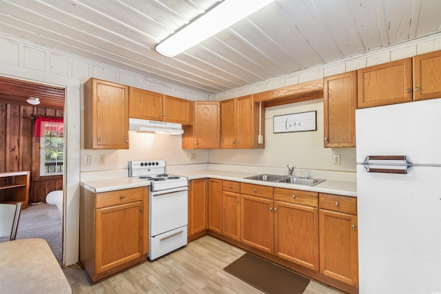 kitchen with light countertops, white appliances, a sink, and under cabinet range hood