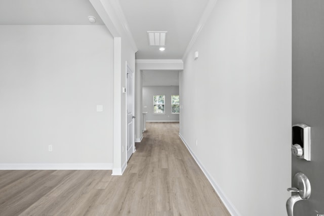 hall featuring baseboards, light wood-style floors, and ornamental molding