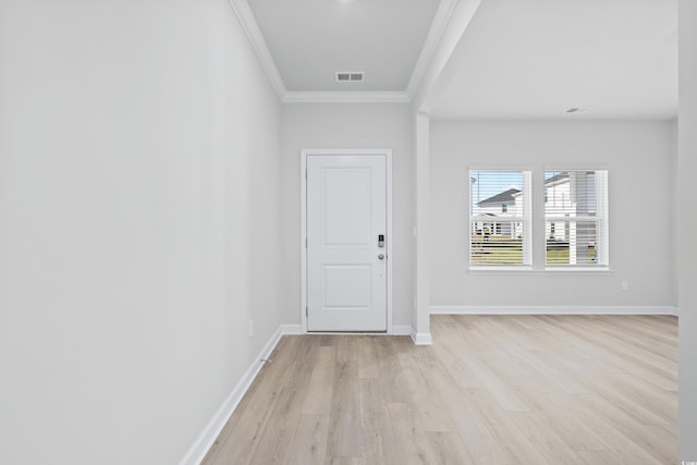 foyer entrance with crown molding, visible vents, baseboards, and light wood finished floors