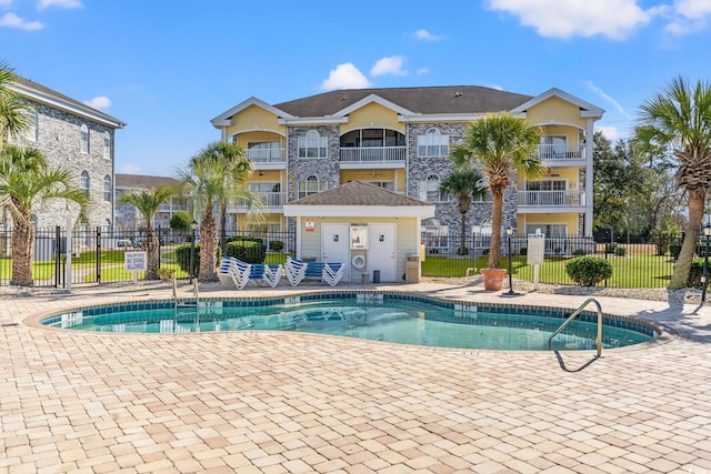 community pool featuring a patio and fence