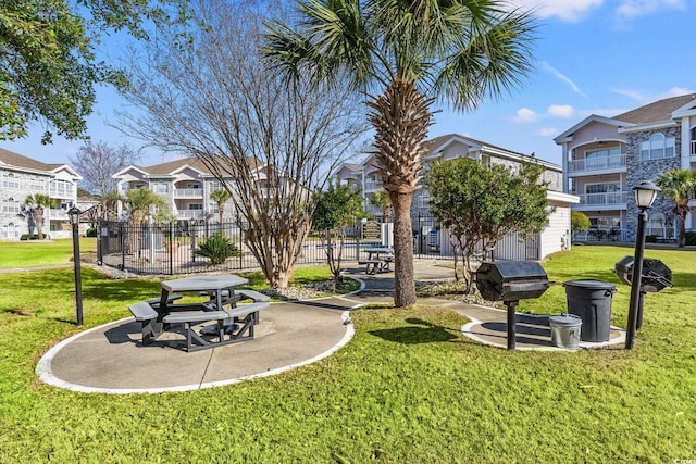 surrounding community featuring a yard, fence, and a residential view