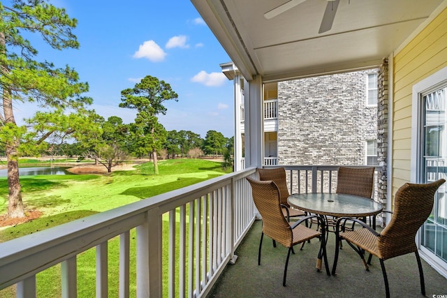 balcony featuring ceiling fan and a water view