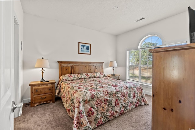 bedroom with visible vents, carpet, and a textured ceiling