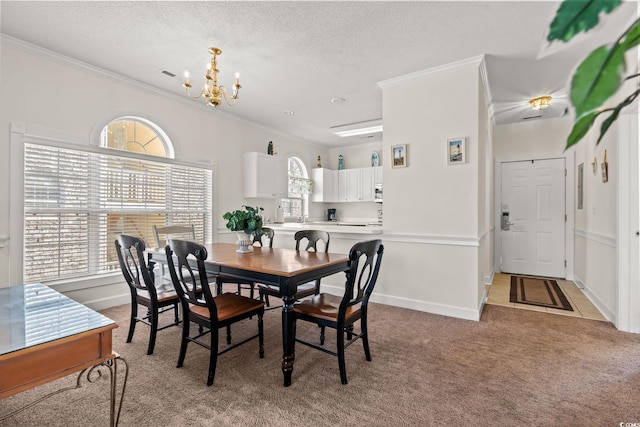 dining area featuring light carpet, a textured ceiling, crown molding, and an inviting chandelier