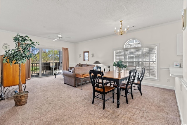 dining space featuring light carpet, ceiling fan with notable chandelier, a textured ceiling, crown molding, and baseboards