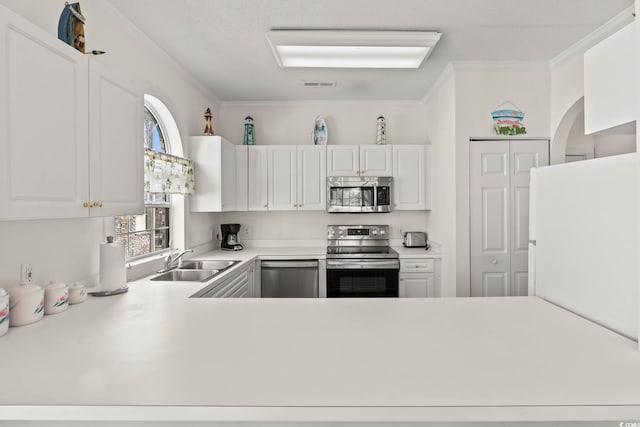 kitchen featuring crown molding, light countertops, stainless steel appliances, white cabinetry, and a sink