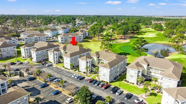 drone / aerial view with golf course view and a water view