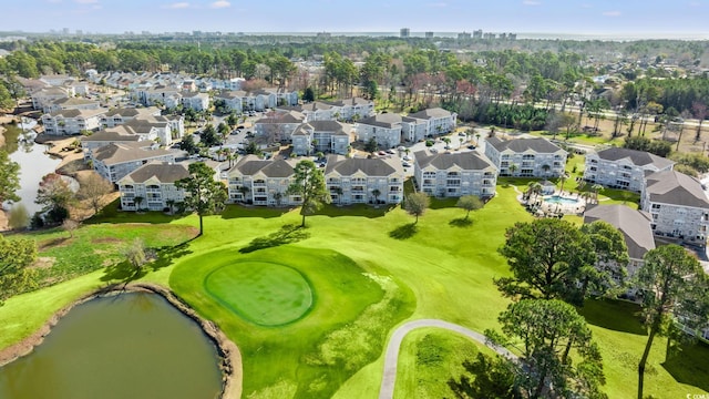 drone / aerial view with a residential view, golf course view, and a water view