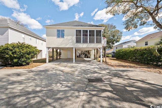 beach home with a carport, a sunroom, and driveway