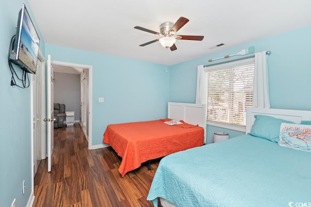 bedroom featuring baseboards, visible vents, ceiling fan, and wood finished floors