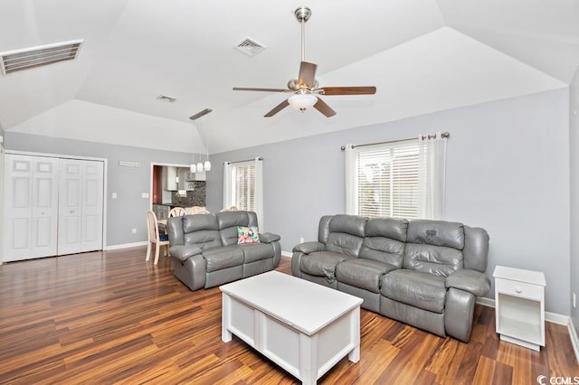 living area featuring lofted ceiling, wood finished floors, and visible vents