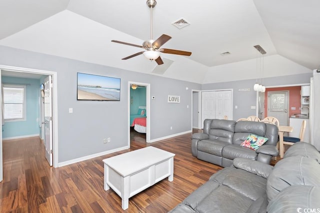 living area with wood finished floors, a ceiling fan, visible vents, vaulted ceiling, and baseboards