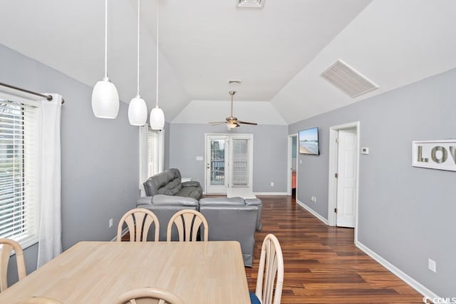 dining space featuring dark wood finished floors, lofted ceiling, visible vents, ceiling fan, and baseboards