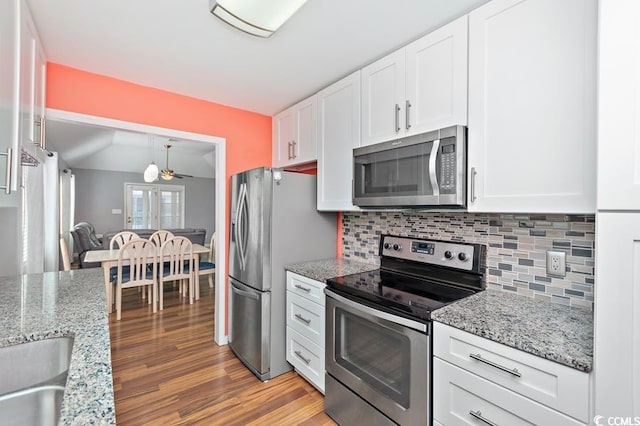 kitchen with stainless steel appliances, tasteful backsplash, light wood-type flooring, and white cabinets