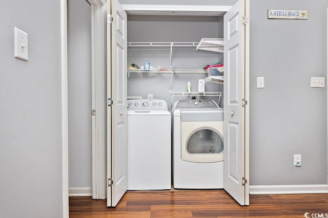 laundry area with wood finished floors, laundry area, baseboards, and separate washer and dryer