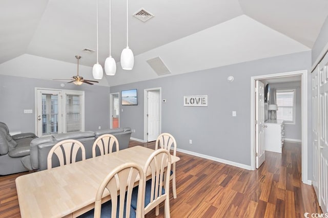 dining area featuring baseboards, visible vents, vaulted ceiling, and wood finished floors